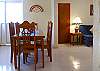 Dining table seats 6. Living room to the right and door to smaller bedroom and bath.