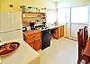 Well equipped kitchen and door to pool patio area.