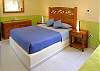 Queen bed and single in large bedroom.