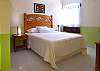 Smaller bedroom with queen bed and private bathroom.