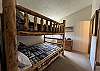 This bedroom is located on the second floor of the condo. It has a bunk bed with a full size bed on top and bottom. Due to weight restrictions, only one person is permitted to sleep on the top bed.