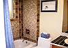 Newly remodeled bathroom has been tastefully decorated with cobblestone and tiled walls in tub area.  Conveniently located off the living room upstairs.