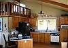 Another view of the kitchen and Queen Loft which has a comfortable Queen mattress, a small window for good ventilation and great ocean views from the high valuted ceiling windows above the living room.