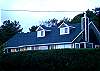 West side view of Shutterbug Cottage.  Located in the quiet community of Arch Cape, this charming beach cottage is encompassed with the beauty of old growth pine trees, nicely landscaped yard and private west hedge.