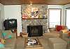 Comfortably furnished living room with beautiful stonework fireplace, satellite TV & DVD.