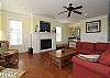 Living Room with Hardwood Flooring, Features a Fireplace, Wet Bar, and Flat Screen TV