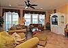 Oceanfront living room with ample seating, ceiling fans, ceramic tile and built-in TV stand with Flat Screen
