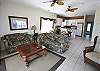 Spacious living room with ceramic tile flooring and ceiling fans. Very nicely decorated.