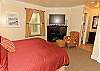 Master bedroom with fireplace, flat screen tv, king bed, and en suite bathroom