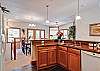 View from the kitchen towards the dining and living areas.  The door to the balcony can seen be past the dining room table.