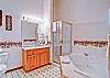 The bathroom offers an oversized jetted-tub with separate shower.
