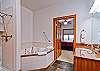 The master bath has a jetted-tub and roll-in shower.