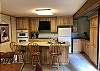 Full Kitchen with Newer Cabinets, Refrigerator, Flat Top Stove, Oven, Microwave, Dishwasher and Coffee Pot.  Deep Stainless Sinks and Tile Floor.