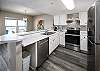 Full service kitchen with white cabinetry and stainless steel appliances 