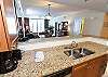 The kitchen looks out into dining and living areas.
