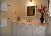 An elongated single vanity can be found in the guest bath, accessible only from the guest bedroom.