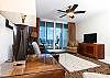 The living room features modern decor with ochre and tan accents.