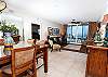 The flooring of the dining room and living room are adorned with tile.