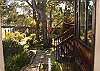 The house is surrounded by oak and pine trees on three sides, gardens with pathways and benches to relax and meditate.