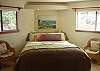 It is large, private and full of light. Beautiful views can be seen from both windows. The door to the left opens to the backyard deck with access to the gardens. Sunset views can be enjoyed from this room and the deck. There is an extra walk-in closet.
