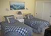 The third bedroom has twin beds, an inside sitting area, adjoining private bathroom access, and opens to a backyard outdoor patio.