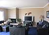 Living room with HD flat panel TV and leather furniture.