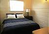 Queen-sized bed with nightstand, dresser and closet.