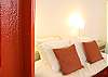 Next to the American queen size bed are matching bedside tables and lamps. You can hide your suitcases in the custom full closet with a full size mirror.