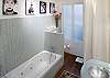 No other apartment on CobbleStay can rival this bathroom. You see artistic prints as you descend down the lighted steps toward the bath tub and separate shower.  There is a combination washer dryer hidden discretely behind the curtain.