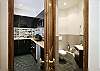 The secondary bathroom is conveniently located off the living room for guests.  The Kitchen is to the left with a window view onto the roofs of Paris.
