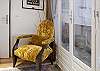 Comfortable Chair back by the bedroom and bathroom, probably a good place to put your shoes on before heading out. Note continuous access to the terrace throughout both sides of the apartment.