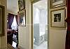 This beautifully style hallway leads to a crisp, white bathroom