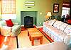The living room is light, bright and cozy with a gas/log fireplace and a Pacific Ocean view! Relax, open the doors and windows, feel the gentle sea breeze and listen to the waves rolling in on the nearby beach!