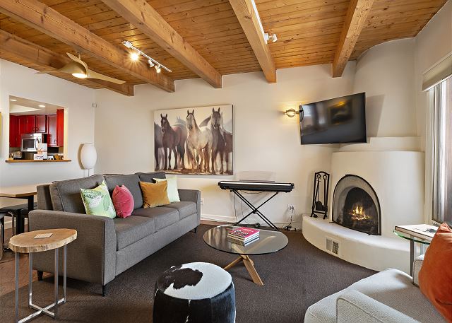 Living area with kiva fireplace, piano, smart TV and a sleeper sofa