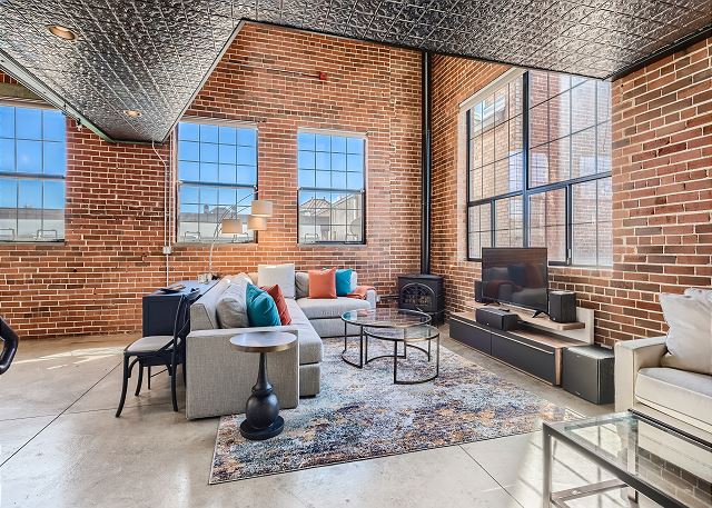 Living Room with Beautiful Exposed Brick Walls, Fireplace, Tin and Vaulted Ceilings, and Smart TV