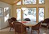 The wall of windows provides natures art work for this dining room setting.