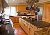 Hard wood floors, granite counter tops and an over head pot rack.