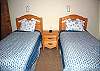 Twin bedroom has TV and access to hall bathroom with tub/shower.