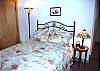 The downstairs queen bedroom is cozy and features floor to ceiling glass for a view of the yard and river. The bathroom is right next door in the hallway.
