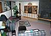 Living room has a great wood fireplace. Lots of space, awesome home for any family wanting to vacation in Sunriver.  Wall behind serves to separate living room from kichen and dining room.