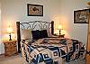 The master suite is complete with a king size bed, TV, walk-in closet, and door to the outside deck.