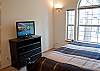 This bedroom has a Queen Size Bed, large windows and a T.V.