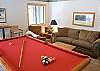 Sit and watch a game of pool on this cozy couch located in the den.
