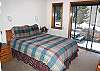 Queen bedroom has TV and access to hall bathroom with tub/shower.