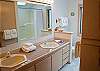 This bedroom has a tub/shower combo and double sink vanity.