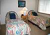 The fourth bedroom of this home includes two twin size beds. It also includes a TV.  This bedroom is to the right of the living room.