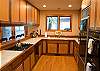 This kitchen offers a double oven, gas range and a large refrigerator.
