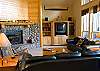 Beautifully appointed living room complete with a large stone gas fireplace and  two comfortable leather couches.