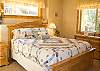 Cheery downstairs bedroom features a queen size bed with access to the hall bathroom.