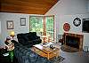 Living Room with Wood Burning Fireplace, TV and VHS/DVD, stereo, and ceiling fan.